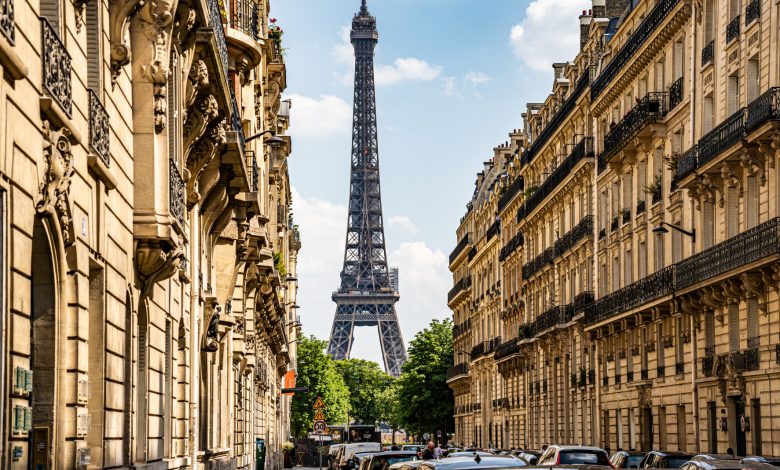 Eiffel tower on the background of a street photo full of cars and medieval buildings